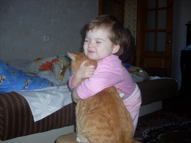ребенок обнимает рыжего кота